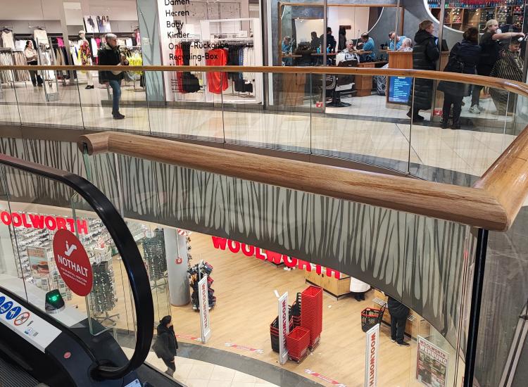 Ganzglasgeländer plan und gebogen mit Holzhandlauf und Glasblenden in München von GLASAKTIV